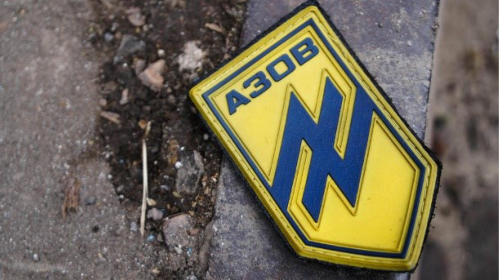 Auf einer Strae in Mariupol liegt ein Abzeichen mit dem Logo des "Asow"-Bataillons. (Quelle: Mihail Andronik/imago images)