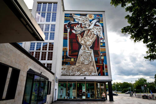 Eisenhttenstadt wurde ab 1950 als Wohnstadt fr das ebenfalls neu erbaute Stahlwerk errichtet. Hier das heutige Linden-Zentrum mit dem Wandbild Arbeit fr den Frieden von Walter Womacka auf der Giebelseite.