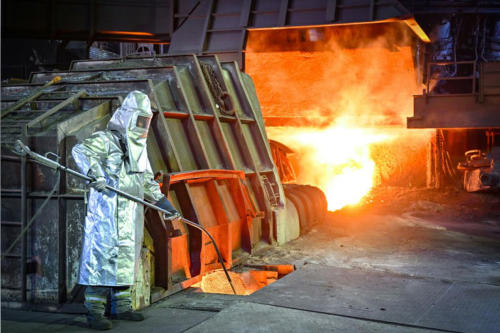 Ein Mitarbeiter in Schutzkleidung berwacht die Temperatur von Roheisen beim Abstich an einem Hochofen der ArcelorMittal Eisenhttenstadt GmbH. 